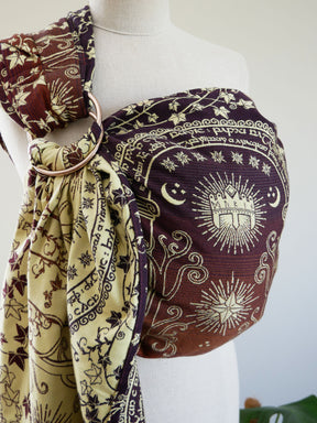 Mannequin wearing a patterned fabric ring sling with Lord of the Ring design on a plain background