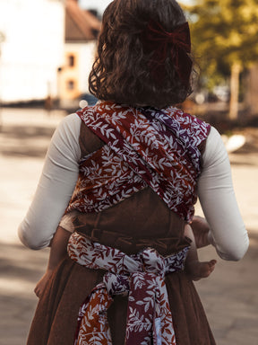 Person wearing a patterned baby carrier outdoors