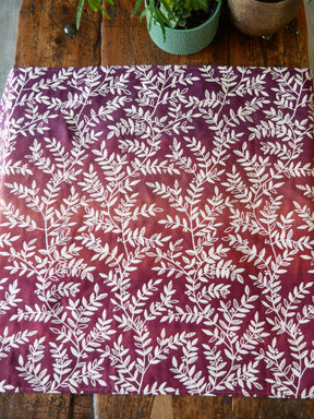 Woven wrap fabric with white leaf pattern on a burgandy purple background