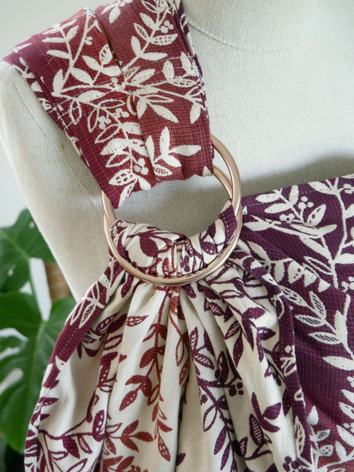 Fabric with floral pattern tied around a mannequin with a champagne ring.
